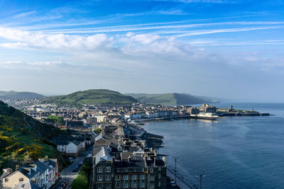 High angle view of townscape by sea against sky