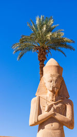 Low angle view of statue against clear blue sky