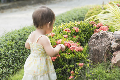 Side view of girl standing amidst plants