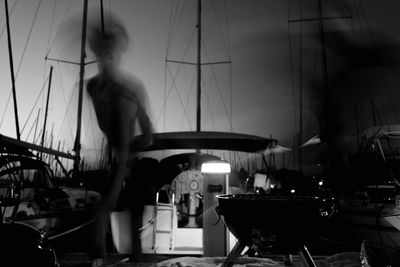 Woman standing in restaurant by sea against sky