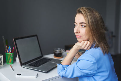 Young woman using laptop at home