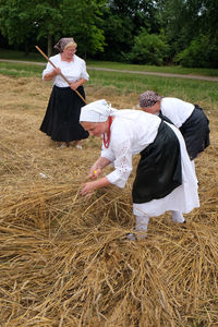 Rear view of couple holding hands on field