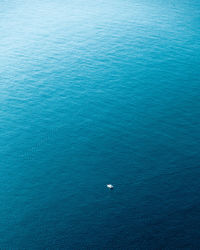 A lone boat, blue waters, and boundless horizons. ideal for travel and maritime projects.