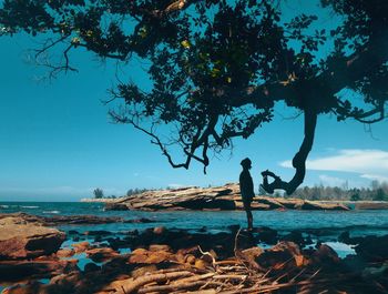 Side view of man on beach against sky