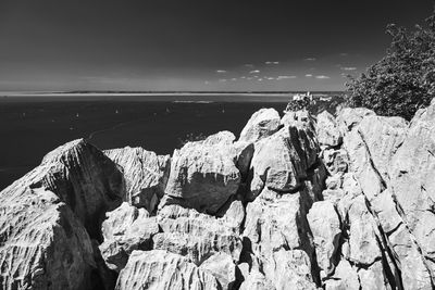 Rock formation on beach against sky