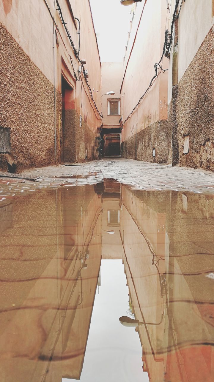 REFLECTION OF BUILDING IN PUDDLE ON WALL