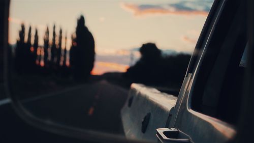 Cropped image of car on street against sky during sunset