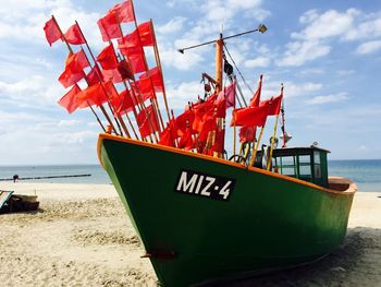 Red flags waving on boat moored at beach