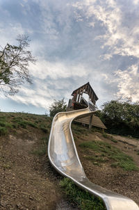Slide at park against sky