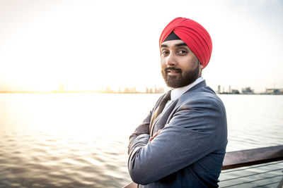 Portrait of businessman wearing turban standing by river