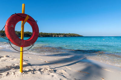 Lifeguard hut on beach against clear blue sky