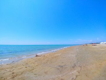 Scenic view of beach against clear blue sky