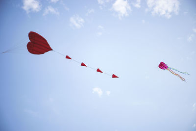 Low angle view of heart shaped kites against sky