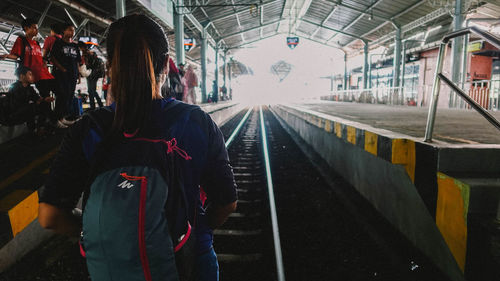 Rear view of woman standing on railroad station platform