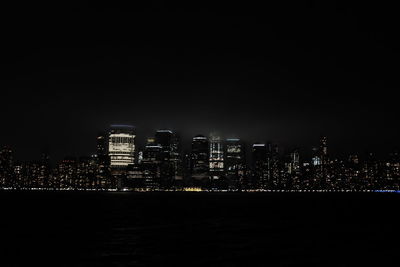 Illuminated buildings in city against sky at night