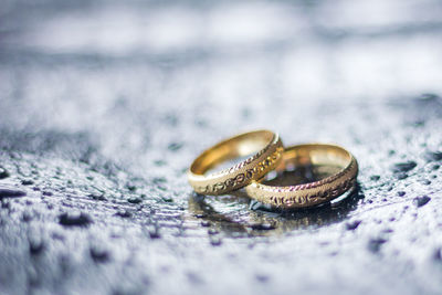 Close-up of wedding rings on wet table