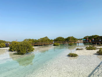 Scenic view of river against clear blue sky