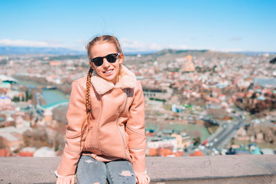 Portrait of young woman wearing sunglasses standing outdoors