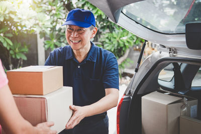 Smiling delivery man giving box to customer