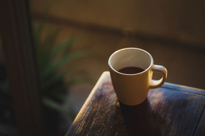 Coffee cup with light and shadow on old wood, morning with coffee