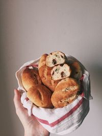 Close-up of hand holding ice cream against white background