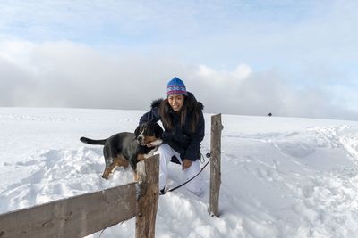 Young woman with dog in snow