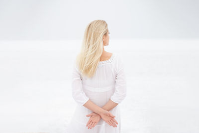 Woman wearing hat standing against white background