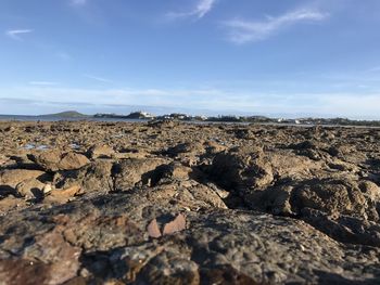 Surface level of rocks on land against sky