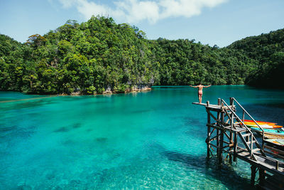 Man standing on diving platform over sea