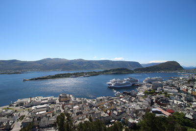 Aerial view of city by sea against clear sky