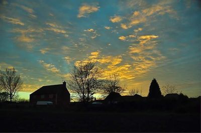 Houses against sky at sunset