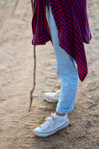 Low section of man standing with umbrella