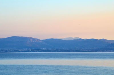 Scenic view of sea and mountains against clear sky