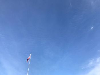 Low angle view of flag against blue sky