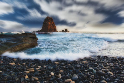 Rocks on beach against sky