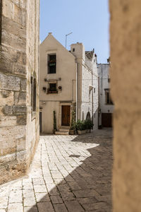 Alley amidst buildings in city against sky