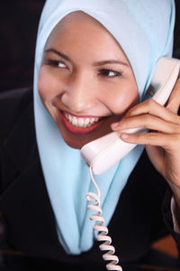 Businesswoman talking on phone while sitting in office