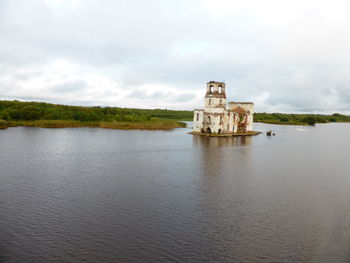 Built structure in lake against sky