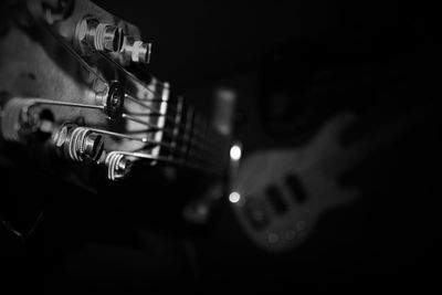 Close-up of hand playing guitar against black background