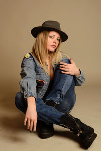 Portrait of woman wearing hat against wall