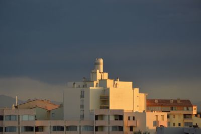 Buildings in city against sky during sunset