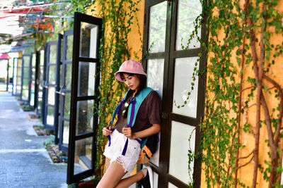 Full length of woman leaning on closed doors