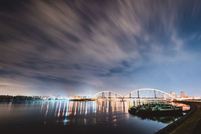 Bridge over river against sky at night