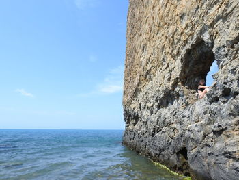 Rock formations by sea against sky