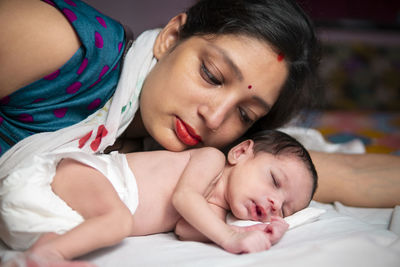 Close-up of cute baby boy lying on bed at home