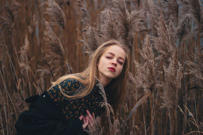 Portrait of beautiful woman standing amidst plants