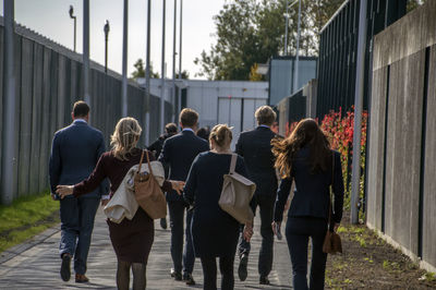 Rear view of people walking on footpath