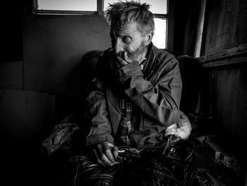 Man looking away while sitting on floor