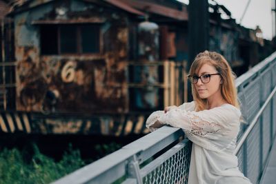 Young woman standing by abandoned train