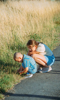 High angle view of boy sitting on grassy field